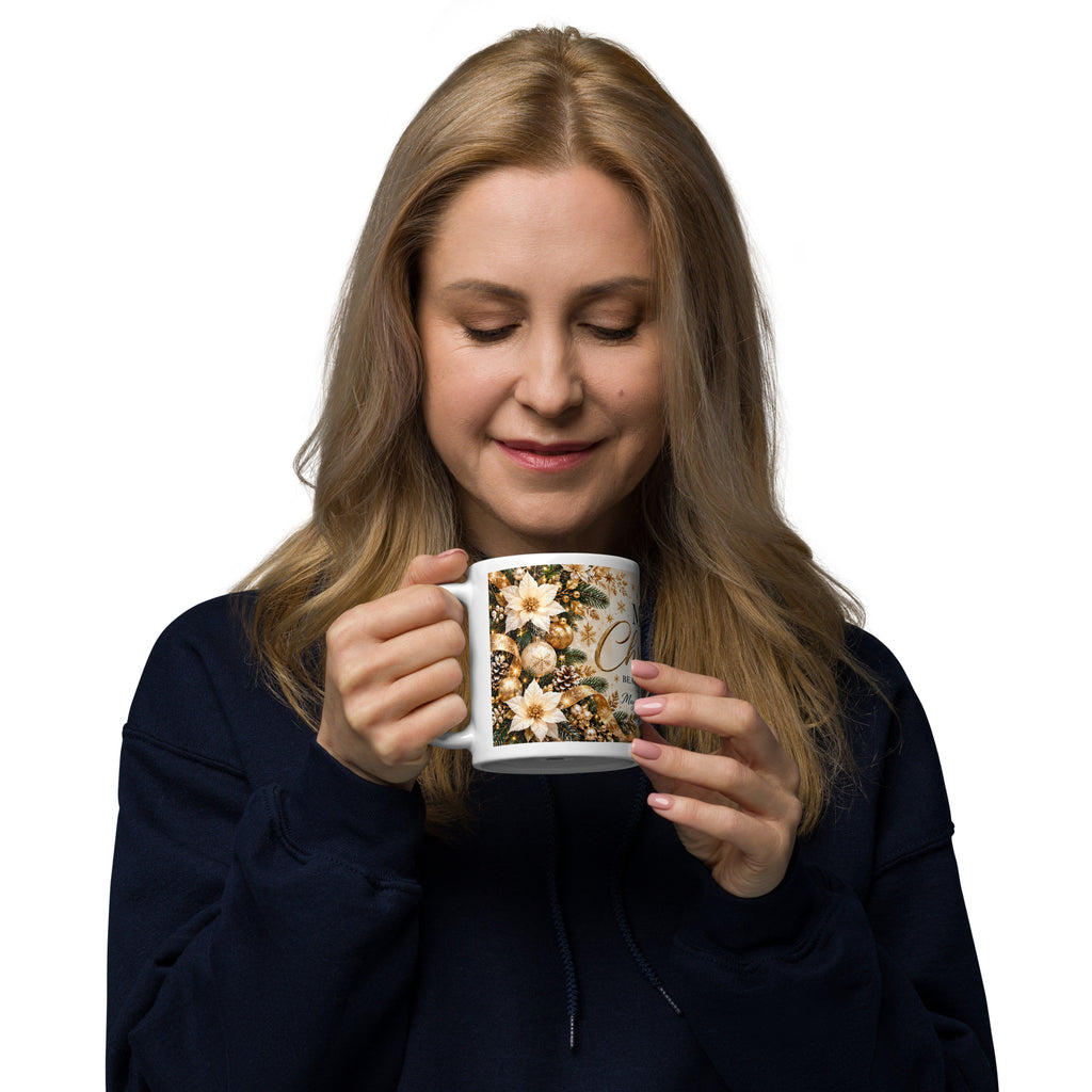 Woman holding a Beauty of Creation Christmas mug with cream flowers, gold ornaments and deep green foliage