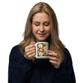Woman holding a Beauty of Creation Christmas mug with cream flowers, gold ornaments and deep green foliage
